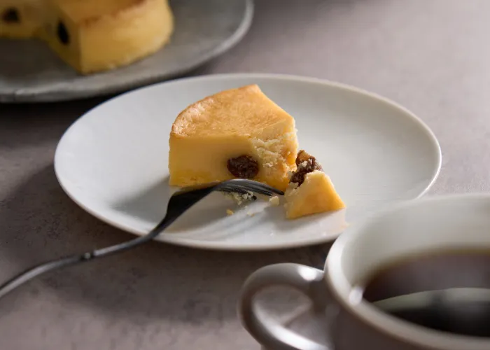 チーズケーキをフォークで切っている写真
