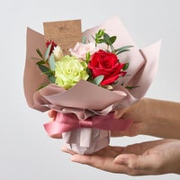 手にのるサイズのカラフルな薔薇のミニアレンジメント