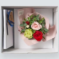 お菓子とバラのアレンジメントが入った箱