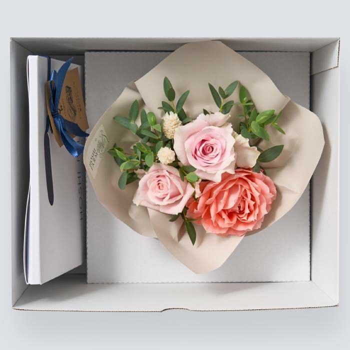 お菓子とバラのアレンジメントが入った箱
